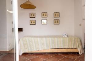 a bedroom with a bed with a green and white blanket at Casa Le Anfore in Anacapri +7 photos