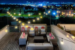 a rooftop deck with couches and lights at night at The Pardi House by Stay Local Nashville in Nashville