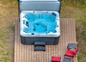 a hot tub sitting on a deck with two chairs at The Pardi House by Stay Local Nashville in Nashville