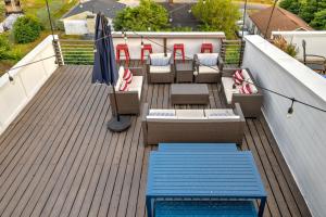a deck with chairs and tables and an umbrella at The Pardi House by Stay Local Nashville in Nashville