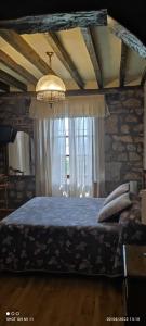 a bedroom with a bed with a blue blanket and a window at Posada Campo in Suances