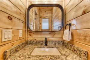 a bathroom with a sink and a mirror at Smokey Peak Inn by Avada Properties in Sevierville +35 photos