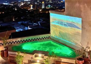 非斯Riad Dar Timrad的夜晚的建筑物顶部的游泳池