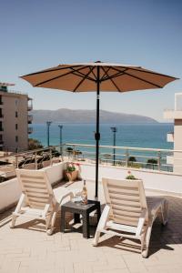 2 sillas y una mesa con sombrilla en el balcón en Rrapi Seaview Penthouse - by EKA Luxury Apartments, en Vlorë 44 fotos más