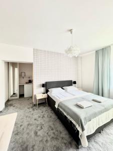 a bedroom with a large bed in a white room at Biały Domek - STREFA CISZY, CHILDREN FREE in Dźwirzyno