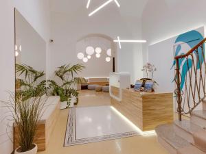 a living room with a staircase and some plants at Hotel Medusa in Finale Ligure