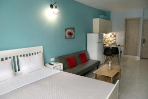 a bedroom with a bed and a couch and a kitchen at Menta Studios, next to metro station, smart tv in Thessaloniki