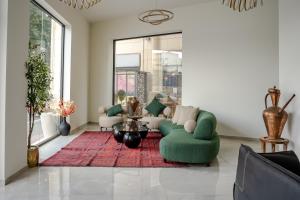 エルサレムにあるLevant Hotelのリビングルーム(緑のソファ、赤い敷物付)