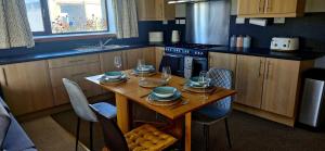 a kitchen with a wooden table with plates and wine glasses at Orkney,Shapinsay in Kirkwall
