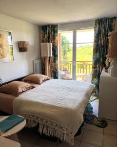 a bedroom with a large bed and a window at Le terrier du Green appartement in Levernois