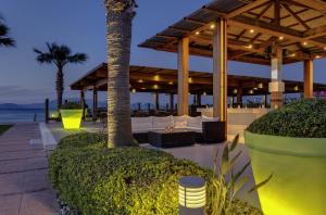 a resort patio with a table and a palm tree at Radisson Blu Resort & Spa Cesme in Çeşme