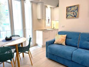a living room with a blue couch and a table at Appartamento Conchiglia Blu di Pietra in Pietra Ligure