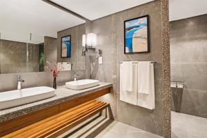 un bagno con due lavandini e due specchi di Kempinski Seychelles Resort a Baie Lazare Mahé