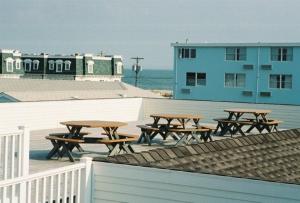 un grupo de mesas de picnic frente a un edificio en Driftwood Dream Unit 12, en Cape May