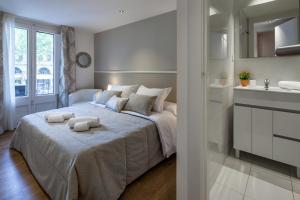 バルセロナにあるHabitat Apartments Parlament Balconiesのベッドルーム1室(ベッド1台、タオル2枚付)