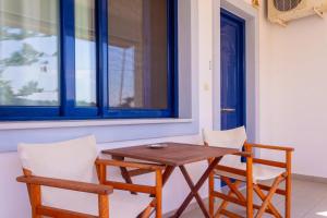 a wooden table and two chairs sitting next to a window at Porto Buffalo Studios in Boufalo