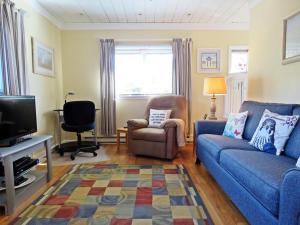 a living room with a blue couch and a chair at Lily Pad Lake Views in Cape May Point