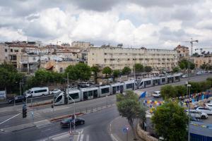 エルサレムにあるLevant Hotelの建物が立ち並ぶ通りに電車が走る街