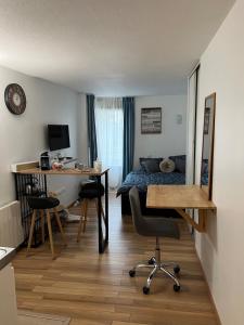 a small room with a bed and a desk and chairs at Charming studio in La Défense with free parking in Courbevoie