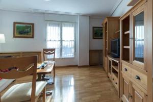 a living room with a dining table and a television at Merlú Alojamiento con garaje in Zamora +6 photos