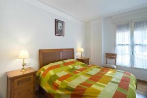 a bedroom with a colorful bed and two lamps at Merlú Alojamiento con garaje in Zamora
