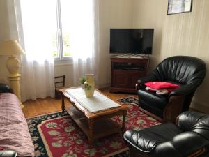 a living room with two leather chairs and a coffee table at Villa Belles Rives in Bellerive-sur-Allier