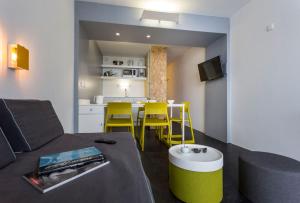 a living room with a couch and a table with yellow chairs at Résidence Le Varet - Arcs 2000 in Arc 2000