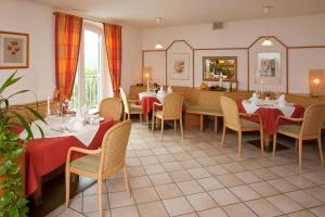 ペルトシャッハ・アム・ヴェルターゼーにあるダス ランドハウス ハウプマンのテーブルと椅子が備わるレストラン