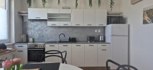 a kitchen with white cabinets and a white refrigerator at Apartmán Vital na Pálavě - ubytování & životní restart in Pasohlávky