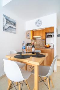 kuchnia z drewnianym stołem i białymi krzesłami w obiekcie Apartment Los Locos Torrevieja Costa Blanca w mieście Torrevieja