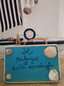 カステッランマーレ・ディ・スタービアにあるIl Rifugio delle Conchiglieの貝殻が積まれた船の前の看板