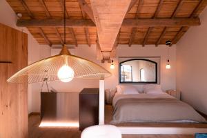 a bedroom with a bed and a large light fixture at Au Chai Bigaroux Saint-Emilion in Saint-Sulpice-de-Faleyrens