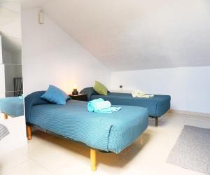 a bedroom with two beds with blue sheets at Casa la Sonrisa shared house in El Médano +19 photos
