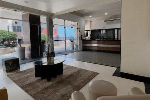 a living room with a glass table and chairs at Apartamento Farol Barra Flat in Salvador