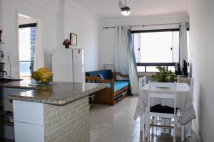 a kitchen with a refrigerator and a table and chairs at Apartamento Farol Barra Flat in Salvador