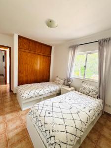 a bedroom with two beds and a window at Alojamento Casa Maria in Moncarapacho