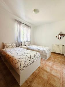 a bedroom with two beds and a window at Alojamento Casa Maria in Moncarapacho