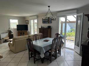 a living room with a table and a couch at Maison spacieuse et lumineuse à seulement 1 minute de la mer in Rosnoën