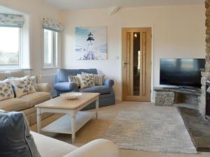 a living room with a couch and a tv at Plas Lodge in Rhosneigr