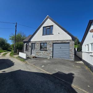 una casa con un garaje en un estacionamiento en Kernyk, en Camelford