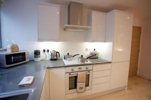 劍橋的住宿－城市住宿公寓- 普林格爾房屋，厨房配有白色橱柜和炉灶烤箱。