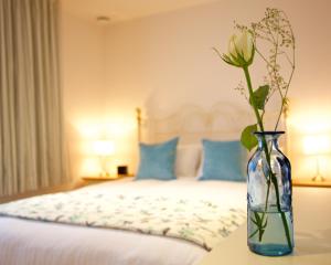 a vase with a flower on a table in a bedroom at Citystay - Pringle House in Cambridge