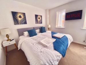 a bedroom with a large bed with blue pillows at Spacious 4-Bedrooms retreat in Walsall -Luxury 3 Bathrooms-Sleeps 9 in Walsall