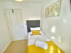 a small bedroom with a bed with a yellow bench at Elegant 4-Bedrooms retreat in Walsall -Luxury 3 Bathrooms-Sleeps 9 in Walsall