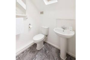 a white bathroom with a toilet and a sink at Spacious 4-Bedrooms retreat in Walsall -Luxury 3 Bathrooms-Sleeps 9 in Walsall
