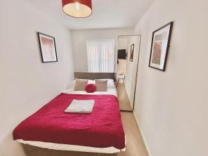 a bedroom with a large bed with a red blanket at Nested 4-Bedrooms retreat in Walsall -Cosy 3 Bathrooms-Sleeps 9 in Walsall