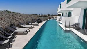 a swimming pool with chaise lounge chairs next to a building at Mastichari Bay Hotel in Mastihari