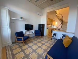a living room with a blue couch and a kitchen at Valletta Seaview TownHouse in Valletta