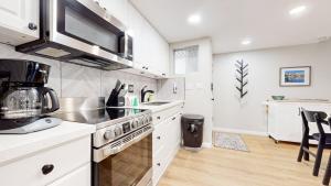 a kitchen with white cabinets and a stove top oven at Mammoth Getaway - Chic Condo in Mammoth Lakes