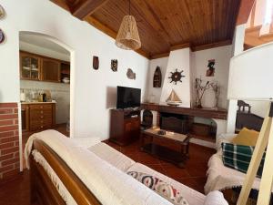 a living room with a couch and a tv at Alojamento Praia do Norte in Leiria